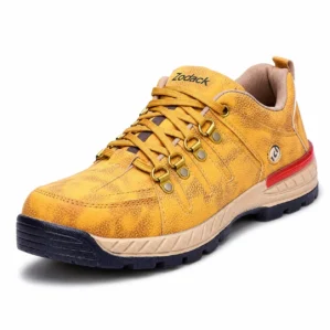 Three-quarter angle view of Zodack men's mustard yellow textured leather outdoor shoe with brass lace hardware, beige midsole, and red heel stripe